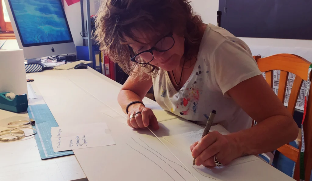 Mirjam Polman writing a calligram at her desk