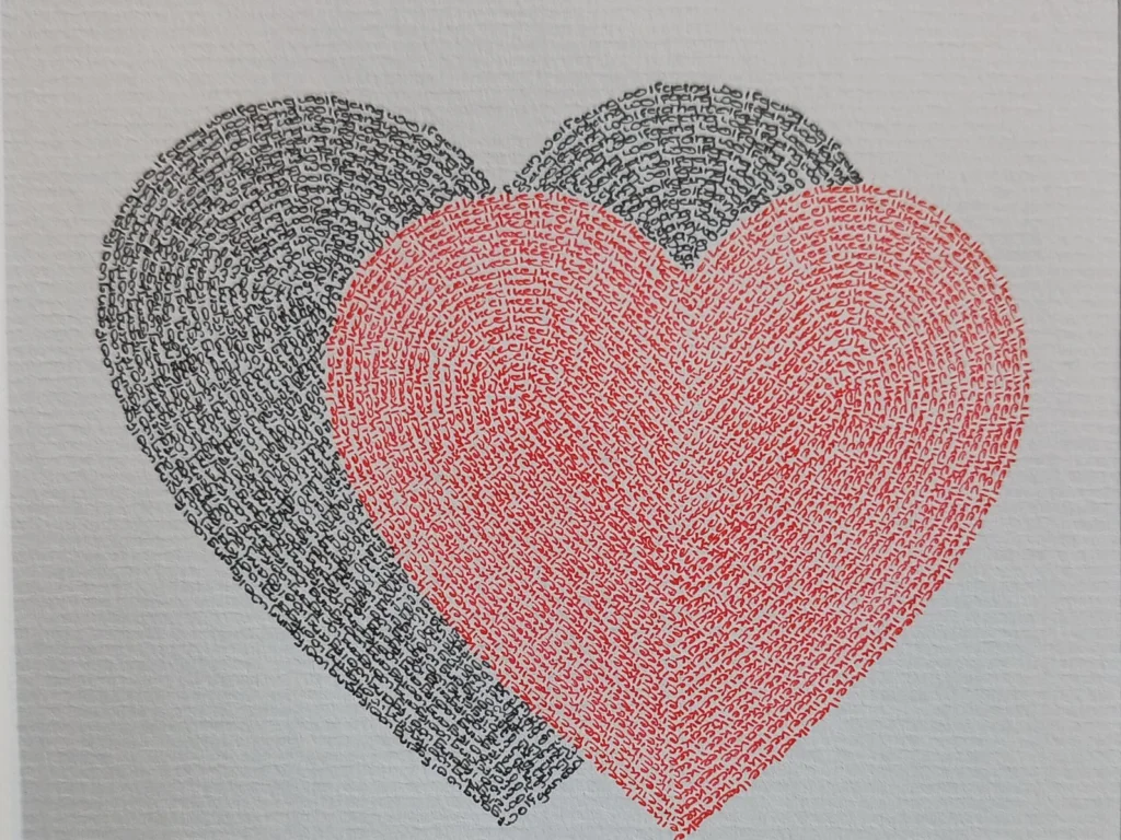 Wedding calligram of two overlapping hearts, one black and one red, written with the names of the couple, with names and date below