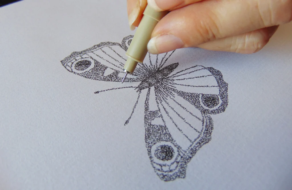 Butterfly calligram being written with a fine pen – the word "mariposa" repeated hundreds of times