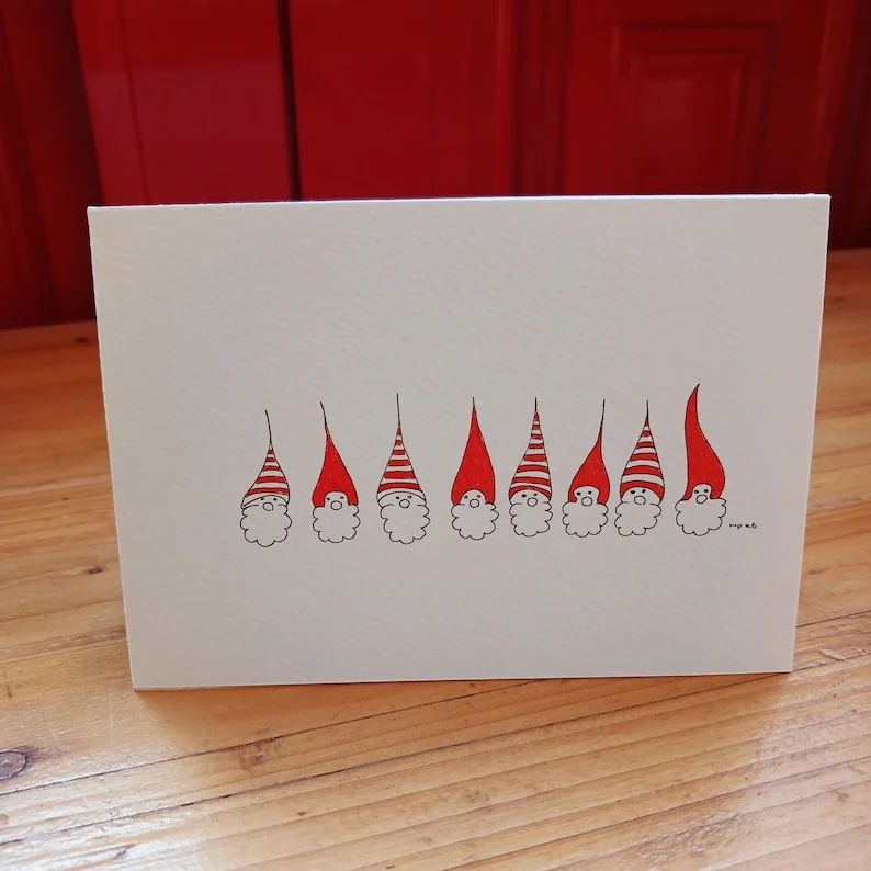 Hand-drawn Christmas card with a row of gnomes in red and striped hats