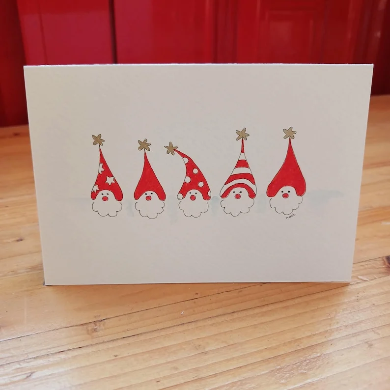 Hand-drawn Christmas card with five bearded elves wearing red hats with golden stars