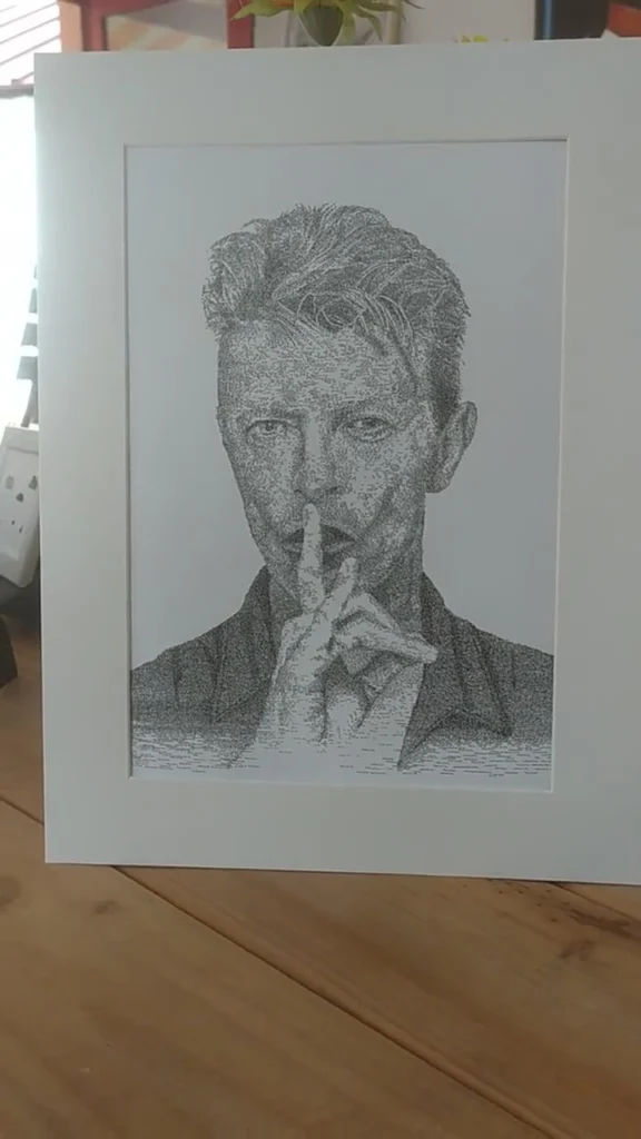 Framed calligram portrait of David Bowie with a finger to his lips, written with his name 4,155 times